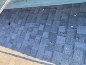 Gray asphalt shingle roof in Las Vegas with visible wear and patch variation