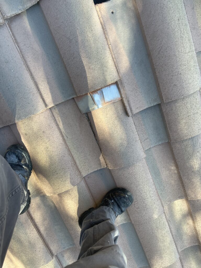 Small metal patch visible between curved roof tiles